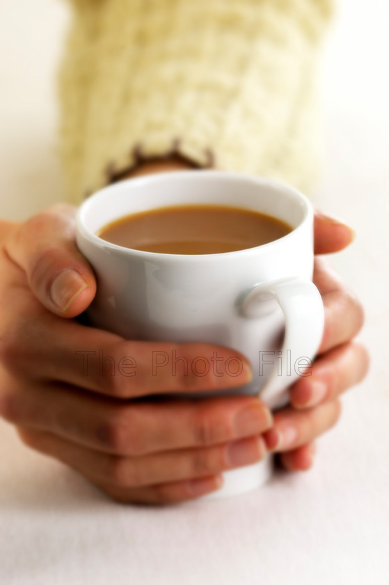 warming hands on mug of tea